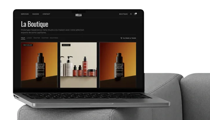 Hella store displayed on a MacBook on a sofa.