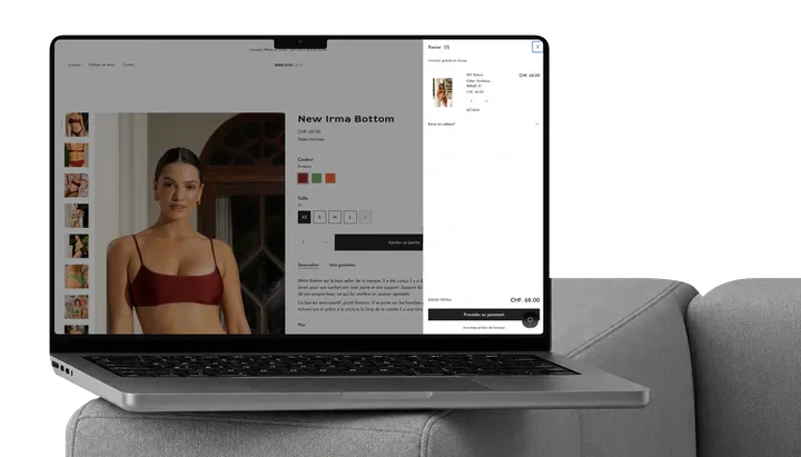 Nomad Tribe Swim store with its cart open, on a MacBook on a sofa.