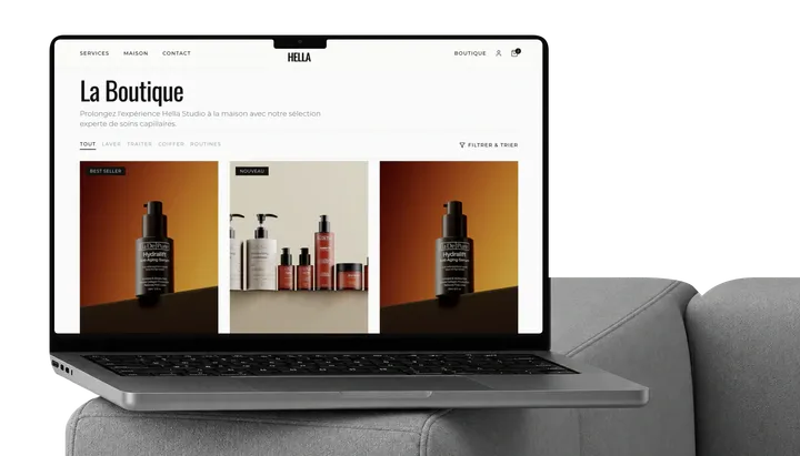 Hella store displayed on a MacBook on a sofa.