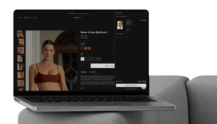 Nomad Tribe Swim store with its cart open, on a MacBook on a sofa.
