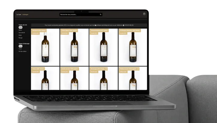 Philippe Darioli wine catalogue on a MacBook on a sofa.